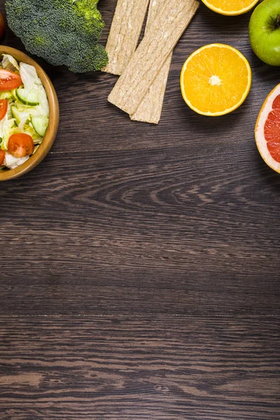 Voedsel voor dieet en het meetlint op een donkere houten tafel. — Stockfoto