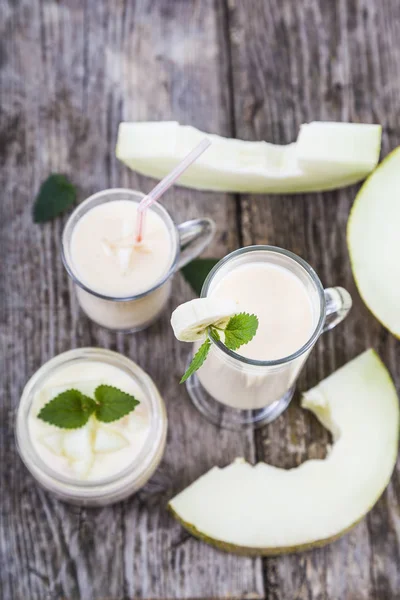 Yogurt e frullato con melone su un tavolo di legno . — Foto Stock
