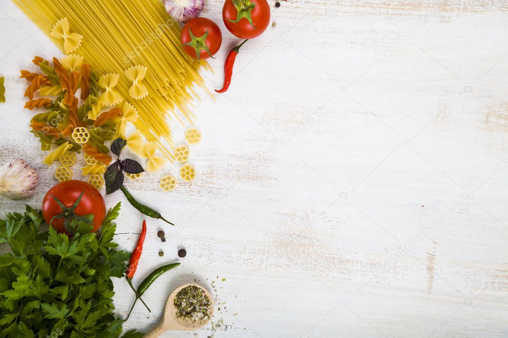 Raw pasta and spices in wooden table. 