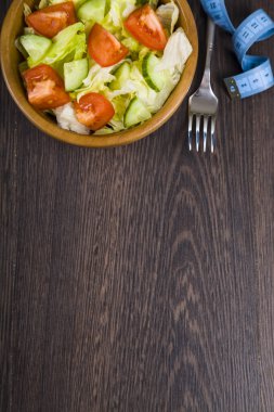 Salata ahşap yay, çatal ve karanlık tablo clo üzerinde ölçüm bandı