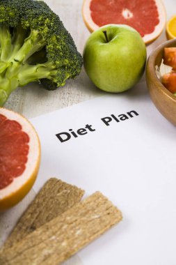 Gıda ve Kağıt ahşap bir masa üzerinde bir diyet planı ile. 