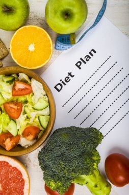 Gıda ve Kağıt ahşap bir masa üzerinde bir diyet planı ile. 