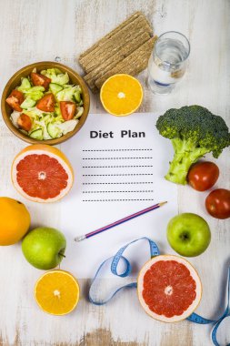 Gıda ve Kağıt ahşap bir masa üzerinde bir diyet planı ile. 