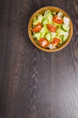 Karanlık tablo yakın çekim üzerinde ahşap kase salata. 