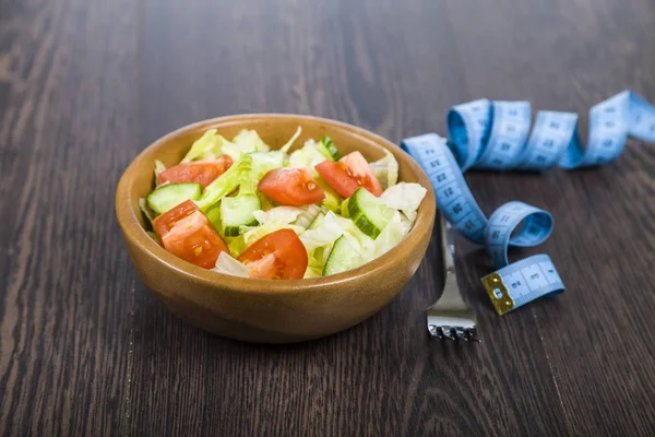 Salata ahşap yay, çatal ve karanlık tablo clo üzerinde ölçüm bandı