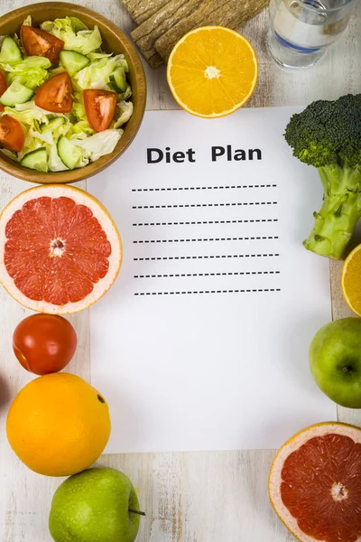 Lebensmittel und Blatt Papier mit Ernährungsplan auf einem Holztisch. con — Stockfoto
