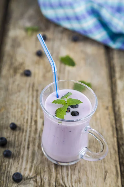 Smoothies ou iogurte com bagas frescas em uma mesa de madeira . — Fotografia de Stock