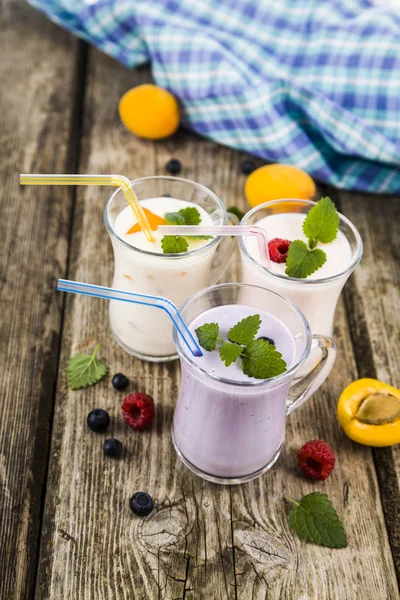 Batidos o yogurt con bayas frescas sobre una mesa de madera . —  Fotos de Stock