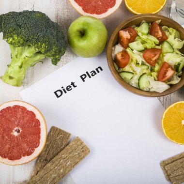 Gıda ve Kağıt ahşap bir masa üzerinde bir diyet planı ile. 