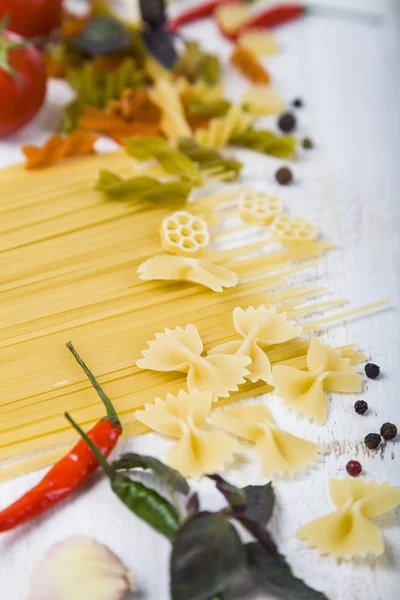 Rohe Pasta und Gewürze in Holztisch. — Stockfoto