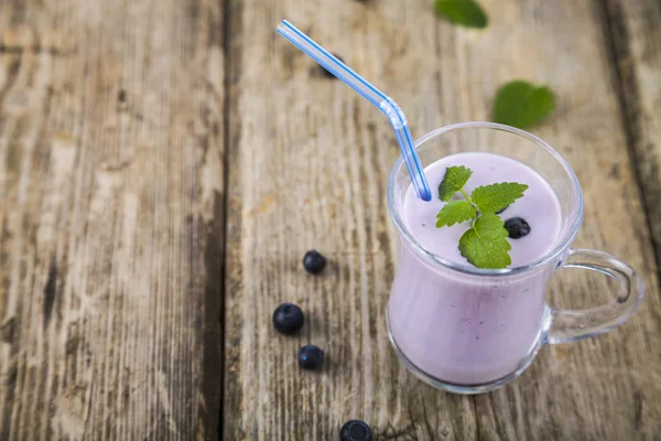 Batidos o yogurt con bayas frescas sobre una mesa de madera . —  Fotos de Stock
