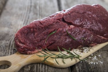 Ahşap tahta üzerinde taze otlar ile sığır eti biftek.