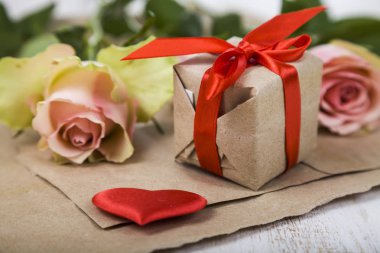 Pembe Gül, hediye ve kalpleri bir ahşap zemin üzerine.