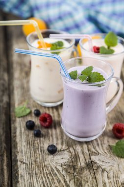Smoothies veya yoğurt ahşap bir masa üzerinde taze çilek ile.