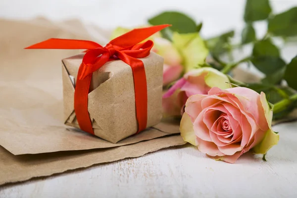 Rosas rosadas, regalos y corazones sobre un fondo de madera . —  Fotos de Stock