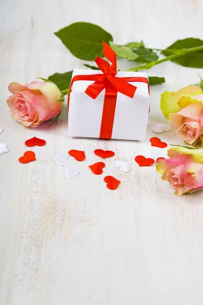 Ροζ τριαντάφυλλα, δώρο και καρδιές σε φόντο ξύλινη. — Φωτογραφία Αρχείου