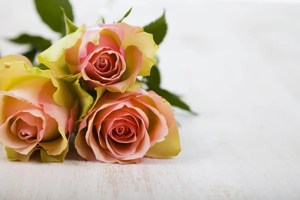 Roze rozen op een houten achtergrond. — Stockfoto