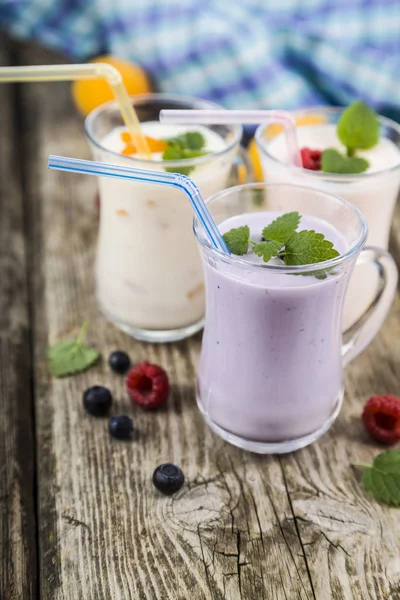 Batidos o yogurt con bayas frescas sobre una mesa de madera . —  Fotos de Stock