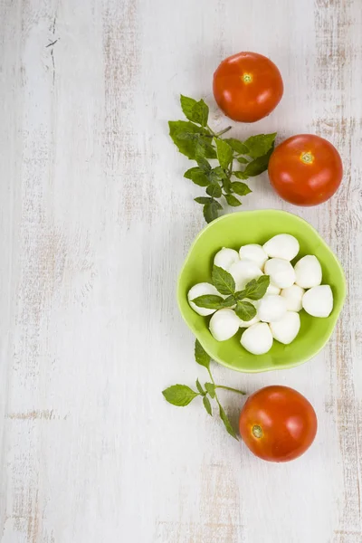 Mozzarella em uma chapa verde em uma mesa de madeira. Bolas de mussarela — Fotografia de Stock