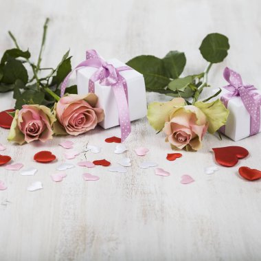 Pembe Gül, hediye ve kalpleri bir ahşap zemin üzerine.  