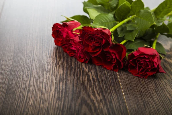 Червоні троянди на темному дерев'яному фоні . — стокове фото