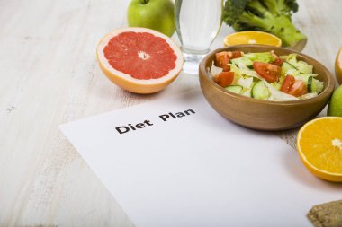 Gıda ve Kağıt ahşap bir masa üzerinde bir diyet planı ile. 