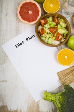 Gıda ve Kağıt ahşap bir masa üzerinde bir diyet planı ile. 