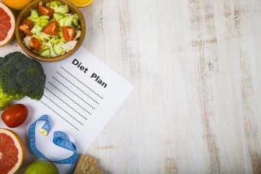 Gıda ve Kağıt ahşap bir masa üzerinde bir diyet planı ile. 
