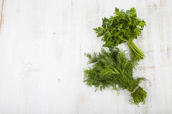 Petersilie und Dill auf hellem Holzgrund. — Stockfoto