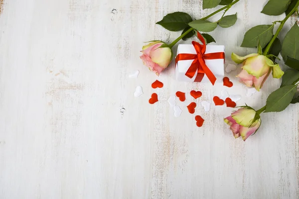 Pink roses,  gift and hearts on a wooden background. — Stock Photo, Image