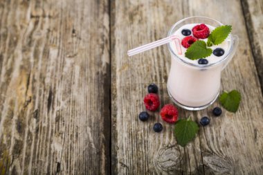 Smoothies veya yoğurt ahşap bir masa üzerinde taze çilek ile. 