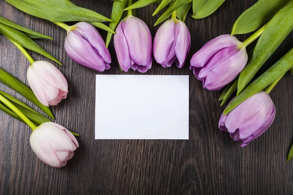 Ramo de tulipanes y una tarjeta para felicitaciones — Foto de Stock