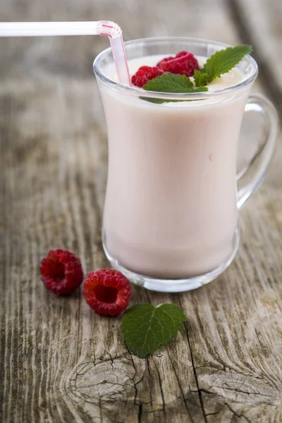 Smoothies ou iogurte com bagas frescas em uma mesa de madeira . — Fotografia de Stock