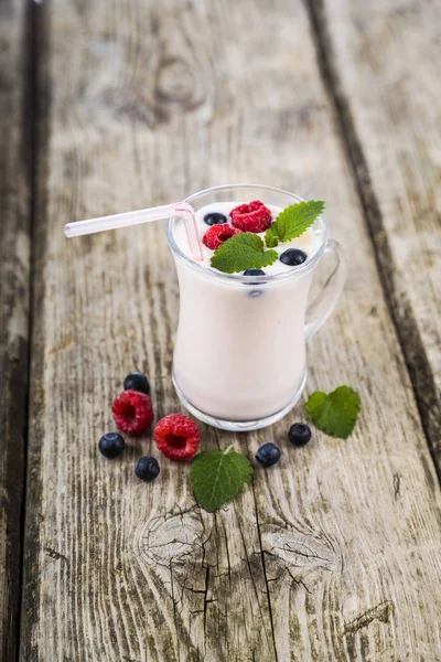 Смузі або йогурт зі свіжими ягодами на дерев'яному столі . — стокове фото