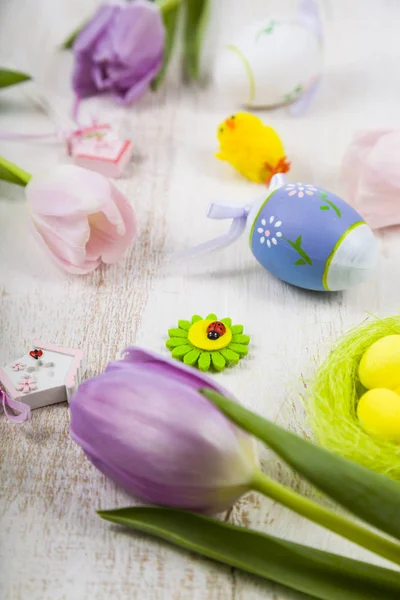 Lila tulipán csokor és a húsvéti tojás egy világos fából készült asztal. — Stock Fotó