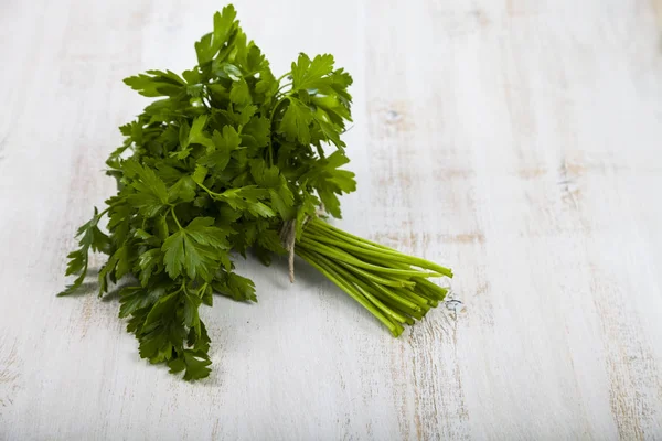 Fresh parsley on a light wooden background.