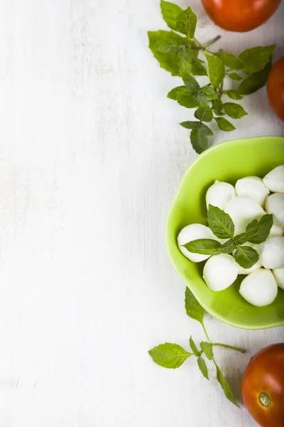 Mozzarella em uma chapa verde em uma mesa de madeira. Bolas de mussarela — Fotografia de Stock