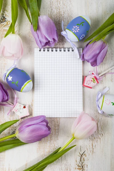 Ramo de tulipanes púrpura, papel y huevos de Pascua en una ligera ta de madera —  Fotos de Stock