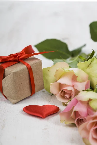 Róż, prezent i serca na tle drewnianych. — Zdjęcie stockowe