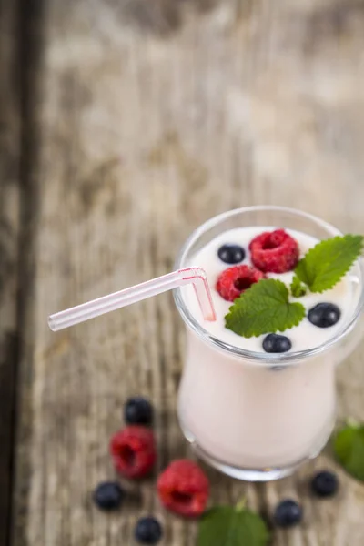 Smoothies ou iogurte com bagas frescas em uma mesa de madeira . — Fotografia de Stock