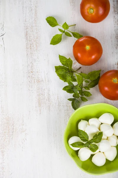 Mozzarella v zelené desky na dřevěný stůl. Kuličky mozzarelly — Stock fotografie