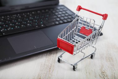 Alışveriş sepeti bir dizüstü bilgisayarda. Online alışveriş kavramı.