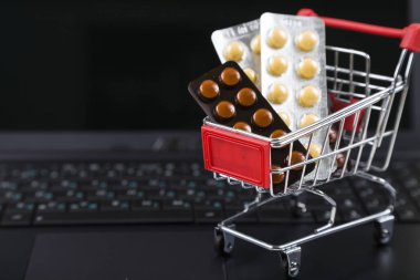 Bir dizüstü bilgisayarda haplarla alışveriş sepeti.