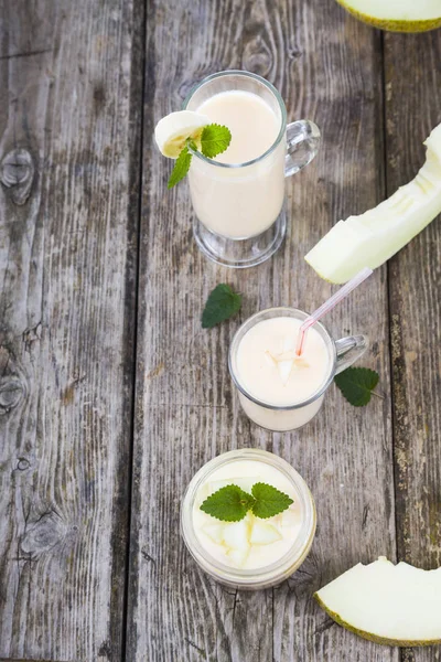 Yogurt and smoothie with melon on a wooden table. — Stock Photo, Image