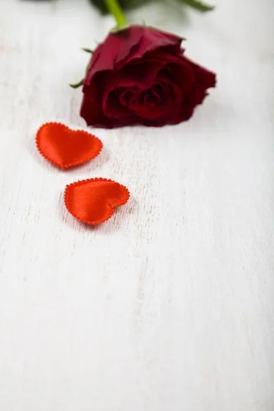 Červené růže a srdce na dřevěné pozadí. — Stock fotografie