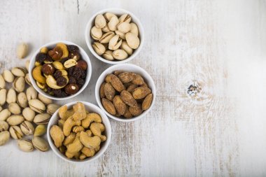 Ahşap bir masa üzerinde bir tabak içinde fındık. 