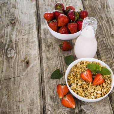 Müsli, smoothies, süt ve ahşap bir masa üzerinde taze çilek