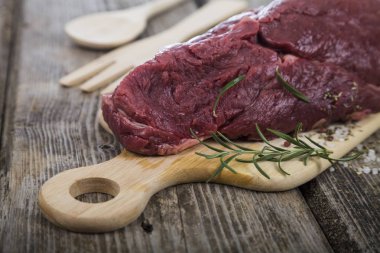 Ahşap tahta üzerinde taze otlar ile sığır eti biftek.