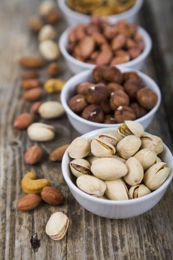 Ahşap bir masa üzerinde bir tabak içinde fındık. 