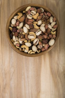 Ahşap bir masa üzerinde bir ahşap kase fındık